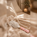 Bluscha Anti Klit Haarborstel roze wit op bed