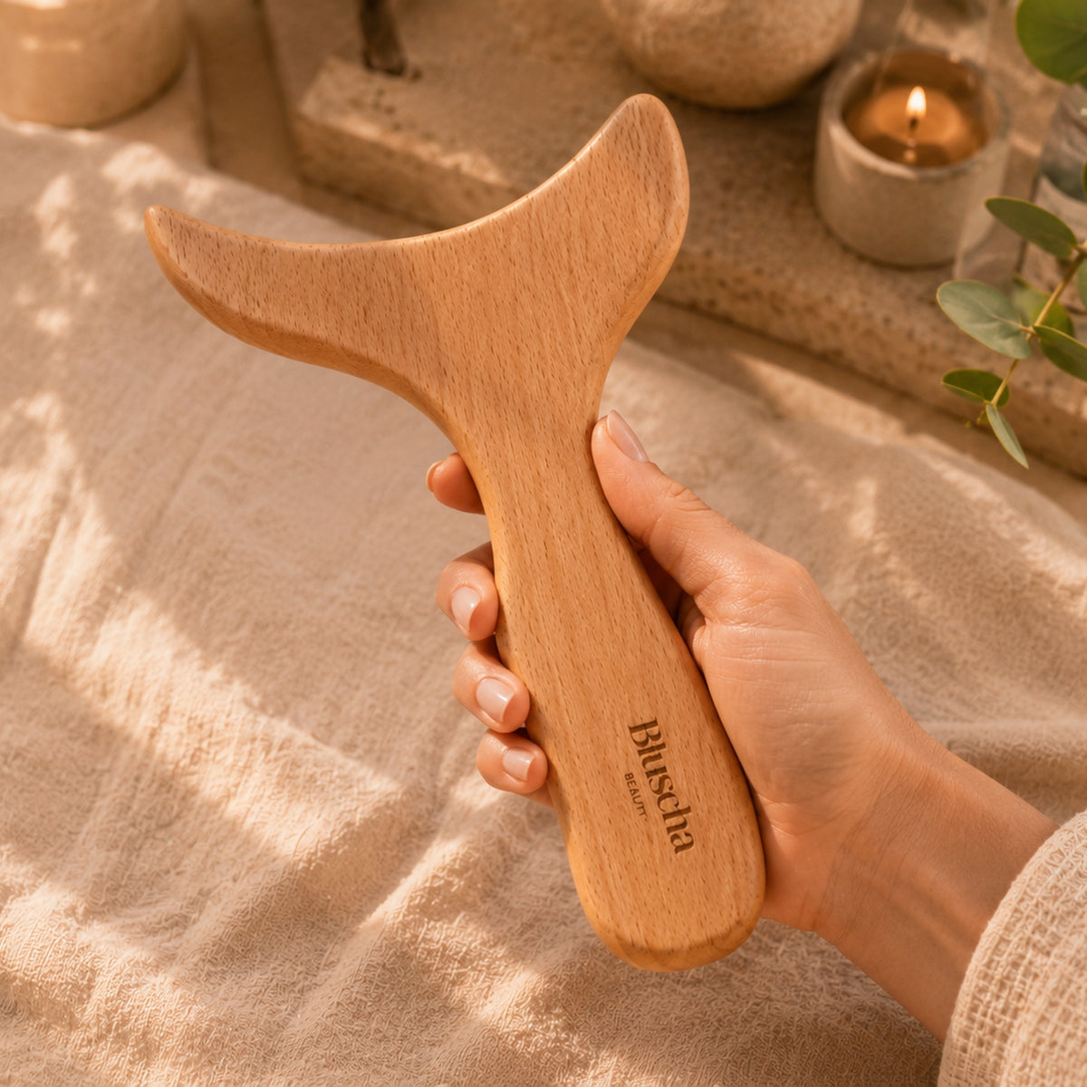 Bluscha houten gua sha massagetool in de hand